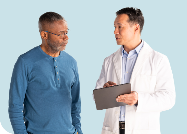 Doctor pointing to a chart and conversing with a patient